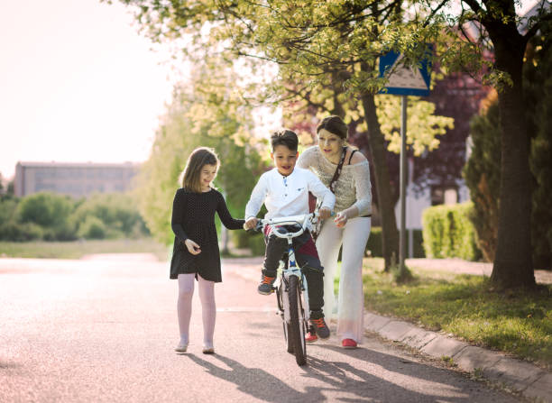 istock mother helping son ride bycicle 670371054