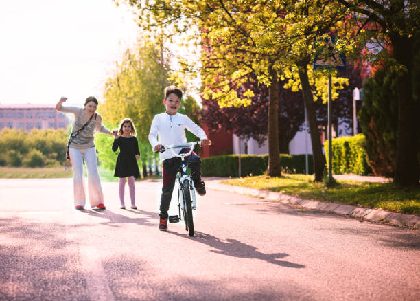 istock mother helping son ride bycicle 670373666