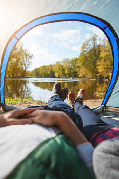 Cropped shot of an unrecognizable couple lying in their tent