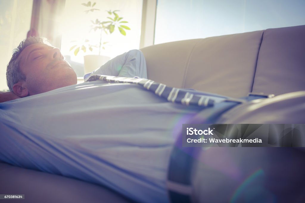 Businessman relaxing on a couch Businessman relaxing on a couch in living room 30-39 Years Stock Photo