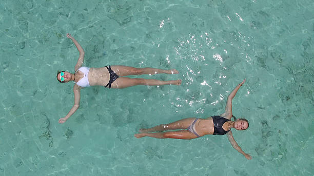 istock Overhead view as two women float in lagoon 670383197