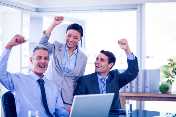 istock Happy business people cheering together 670389998