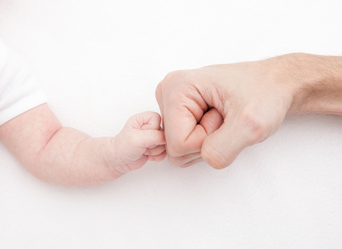 Fist of Dad and Newborn Baby. Fist to fist concept