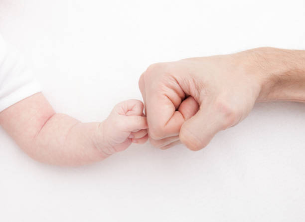 Fist of Dad and Newborn Baby. Fist to fist stock photo