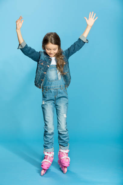 istock little girl in pink roller skates in studio on blue 670401366