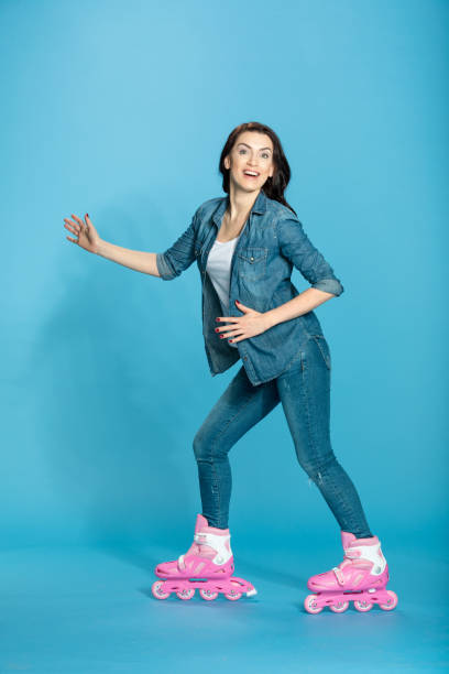 istock happy woman in roller skates having fun in studio on blue 670401668