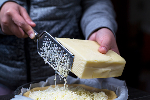 scratching mozzarella cheese, covering on pizza