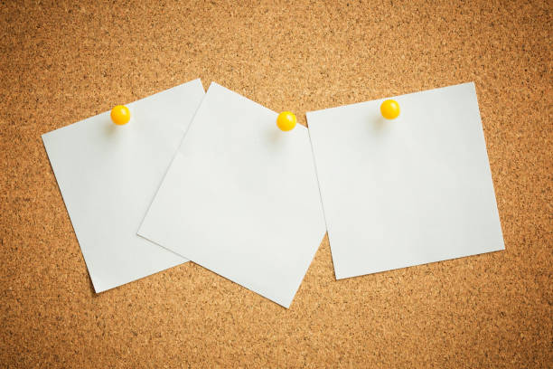 istock yellow pin white paper on cork board texture background note 670402796