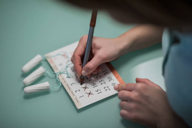 крупным планом женщина пишет свой календарь менструации. - tampon healthcare and medicine menstruation indoors стоковые фото и изображения