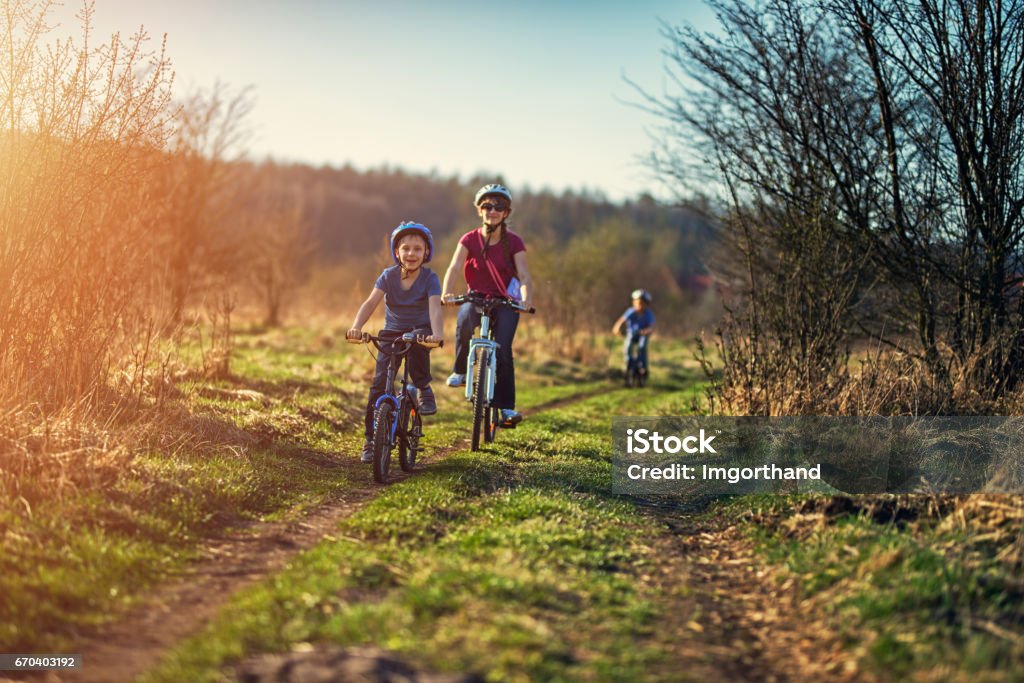 Family riding bicycles on early spring evening Kids riding bicycles on early spring day evening. Cycling Stock Photo
