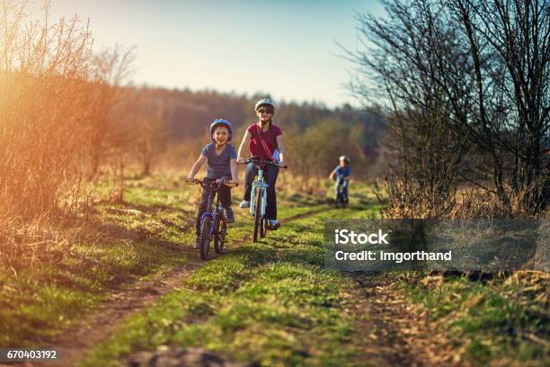 Family Riding Bicycles On Early Spring Evening Stock Photo - Download Image Now - Cycling, Springtime, Bicycle