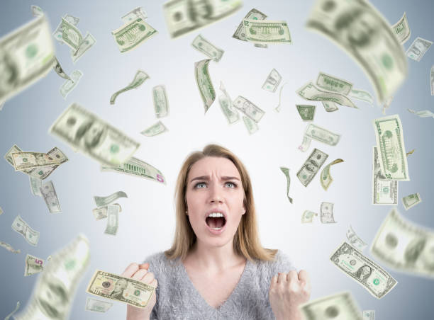 istock Stressed woman under dollar rain 670406646