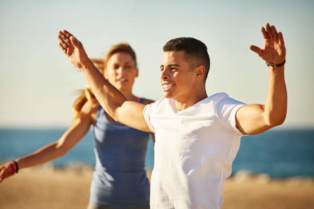 istock Athlete with arms outstretched exercising at beach 670410202