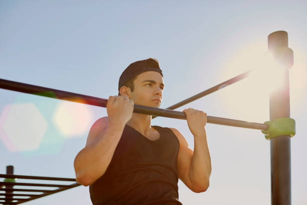 istock Determined male athlete doing chin-ups on bar 670411020