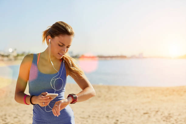 istock Sporty woman using smart phone and watch at beach 670411052