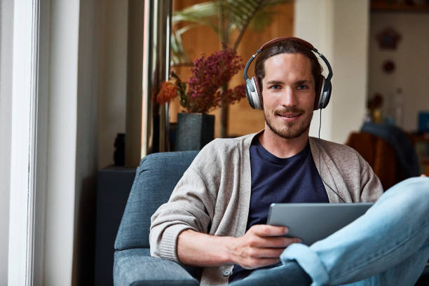 istock Confident man with headphones and tablet PC 670411440