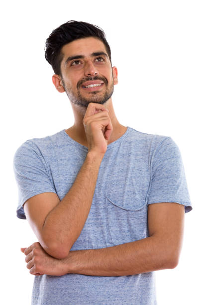 istock Studio shot of young happy Persian man smiling and thinking while looking up 670412018
