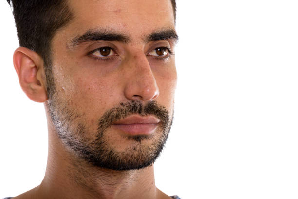 Close up of young Persian man thinking while looking at distance horizontal shot