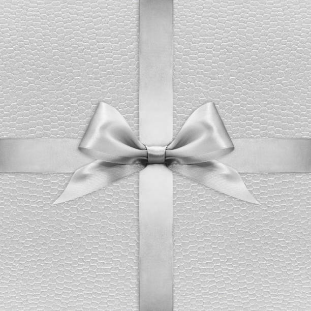 istock Shiny silver satin ribbon bow on argent background 670414490