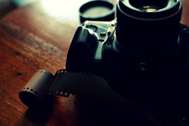 istock Analog photo camera and a roll of film 670414604