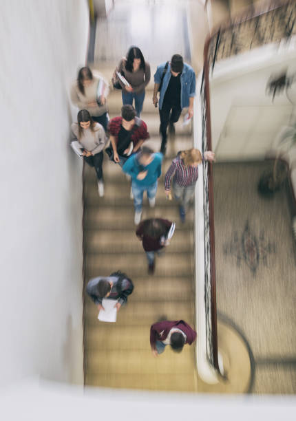 Above view of students walking down the stairs in blurred motion.