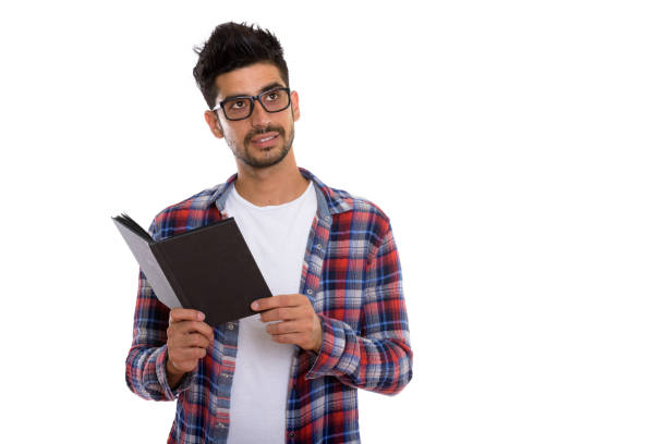 istock Studio shot of young Persian man wearing eyeglasses and holding book while thinking 670417768