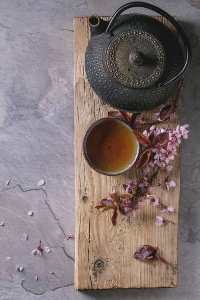 istock Teapot and cup of tea with blossom branch 670421396