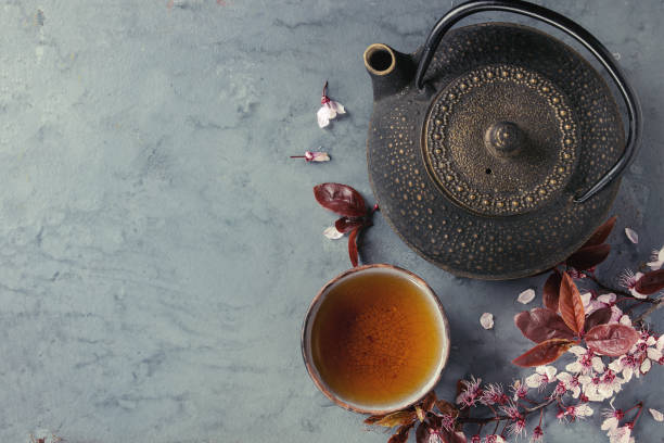 istock Teapot and cup of tea with blossom branch 670421398