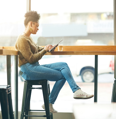 Shot of an attractive young woman using a digital tablet in a cafe