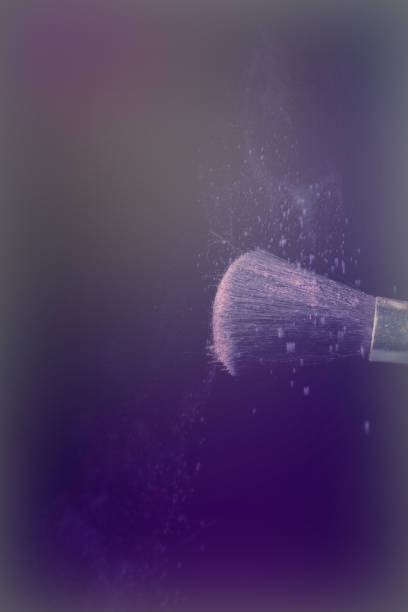 istock Make up brush with purple dust on black background 670425476