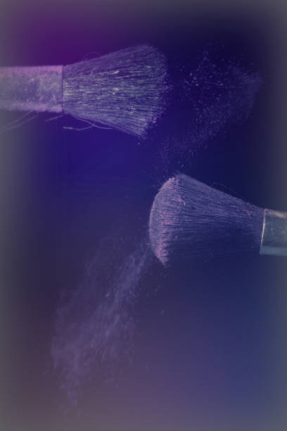 istock Make up brush with purple dust on black background 670425480