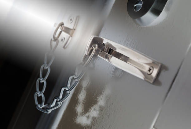 Door chain on a grey door, security measures