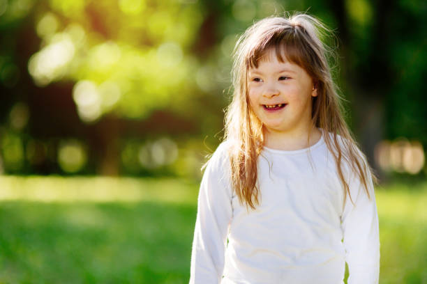 istock Beutiful happy child suffering from Down syndrome smiling outdoors 670434006