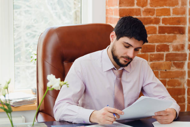istock A young man sits at a desk in the office. 670440232
