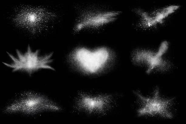 Photo of Freeze motion of 9 white powder shapes, isolated on black,