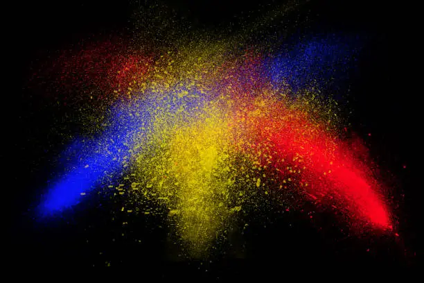 Photo of Freeze motion of colorful powder exploding isolated on black,