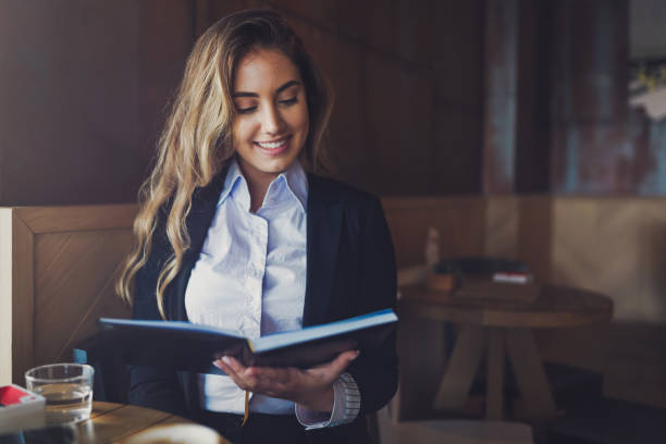 istock Beautiful woman reading notebook in cafe 670443010