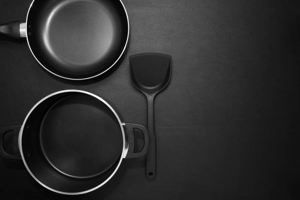 istock Top view frying pan and pot on black table. 670443488