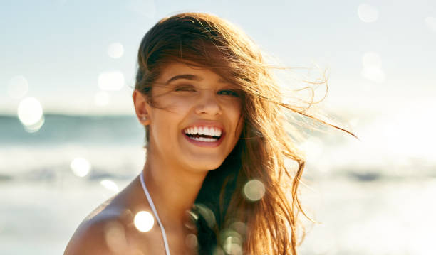 Life’s at ease with an ocean breeze Closeup shot of a beautiful young woman spending some time at the beach complexion photos stock pictures, royalty-free photos & images