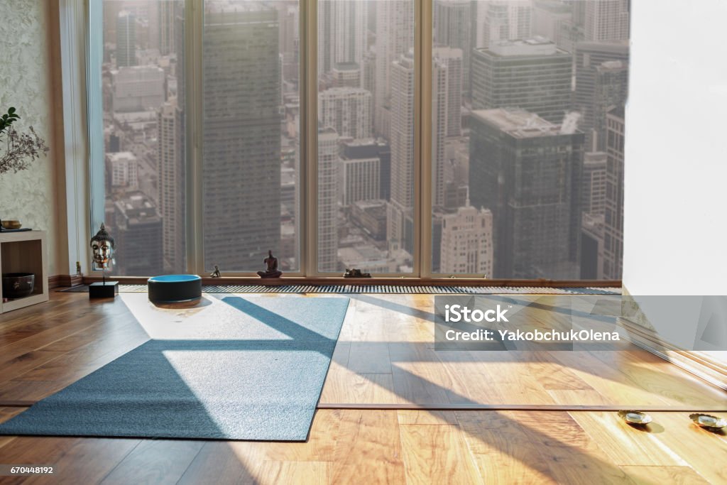 Place for meditation and relaxation Special room for doing yoga in human apartment. Mat on floor near window with city view Exercise Mat Stock Photo