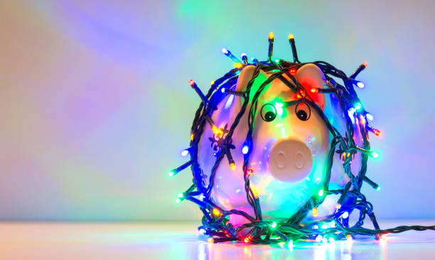 Piggy bank wrapped in Christmas string lights stock photo