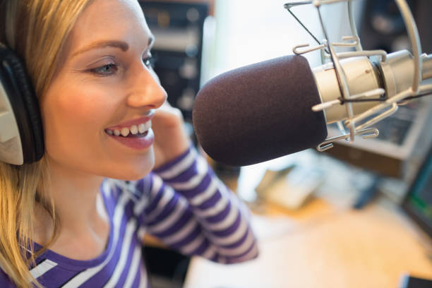istock Happy young female radio host broadcasting in studio 670450306