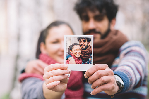 Couple showing instant photo to the camera