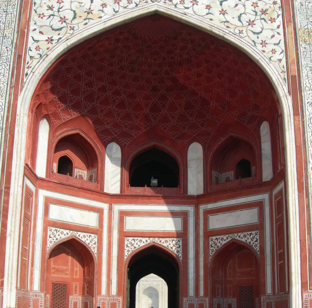 Taj Mahal mausoleum complex in Agra, India with its decorated main gate cupola, and arched entry portal.