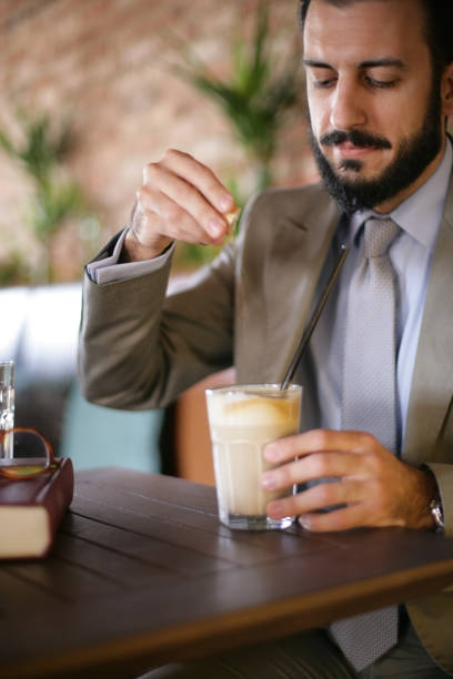 istock Bearded Man putting sugar in his coffee 670460770