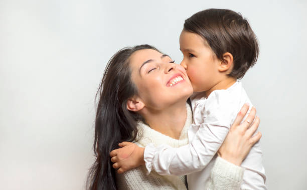 little girl  kissing her mother stock photo