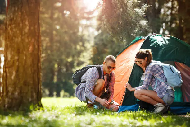 Campers setting up the tent at the forest.