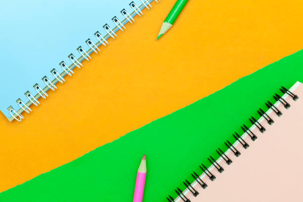 istock pencil and notebook on colorful paper background 670467208