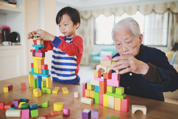 enkel und oma spielen mit blöcken - great grandson stock-fotos und bilder