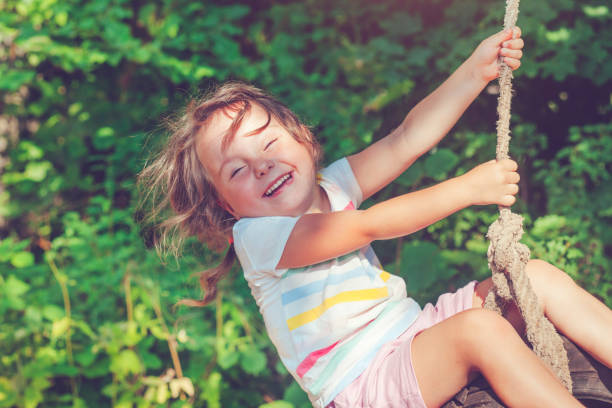 little girl swinging in summer - freedom tire swing tire swing imagens e fotografias de stock